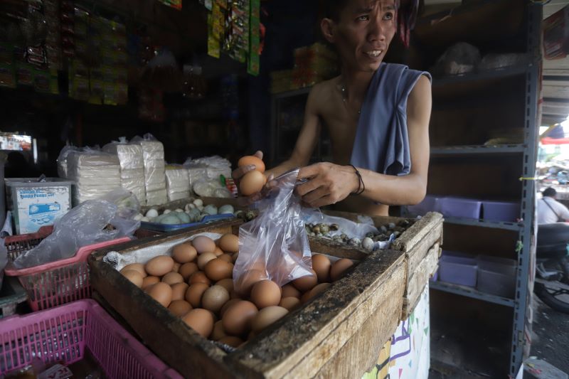 KIAN MAHAL: Pedagang telur ayam di Pasar Tanjung Anyar, Kota Mojokerto, sedang melayani pembeli, kemarin (13/10).