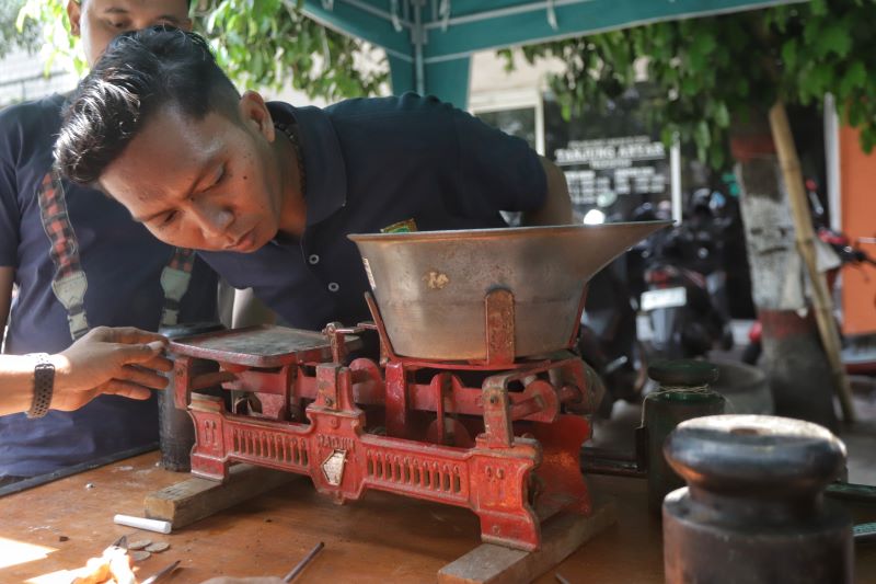 DIUKUR ULANG: Petugas Diskopukmperindag Kota Mojokerto melakukan tera ulang pada alat timbang meja milik pedagang di Pasar Tanjung Anyar, kemarin (15/10).