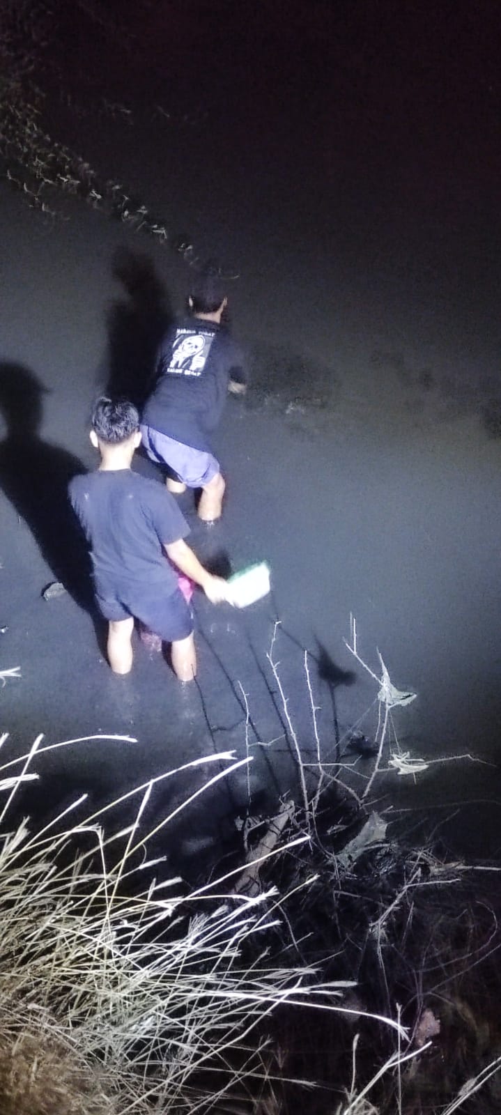 CARI IKAN: Warga cari ikan dengan ember turun ke Kali Sadar yang surut di kawasan Tropodo, Kota Mojokerto, Kamis (17/10) malam.