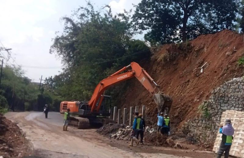 JANGKA PENDEK: Pekerja Dinas PUPR Kabupaten Mojokerto memasang tiang pancang mini pile di tebing Jalan Raya Dusun Kambengan, Desa Cepokolimo, Kecamatan Pacet, kemarin (17/10).
