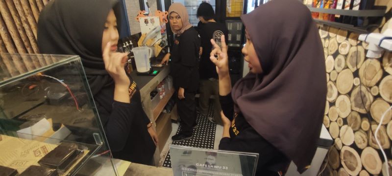 AJAK MANDIRI: Dua pramuniaga Cafe Lawu 33 dari siswa SLB berinteraksi menggunakan bahasa isyarat ketika melayani pengunjung, Jumat (3/10).