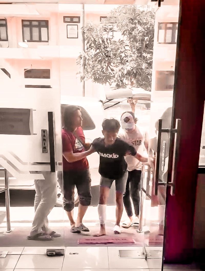 PINCANG: Sambil tertatih-tatih Farhan (tengah) dikeler petugas ke Mapolres Mojokerto untuk diproses lebih lanjut.