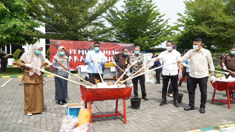 DIBAKAR: Kajari Kota Mojokerto Bobby Ruswin (tengah) memusnahkan sejumlah barang bukti tindak pidana di halaman kantor kejaksaan, kemarin (21/10).