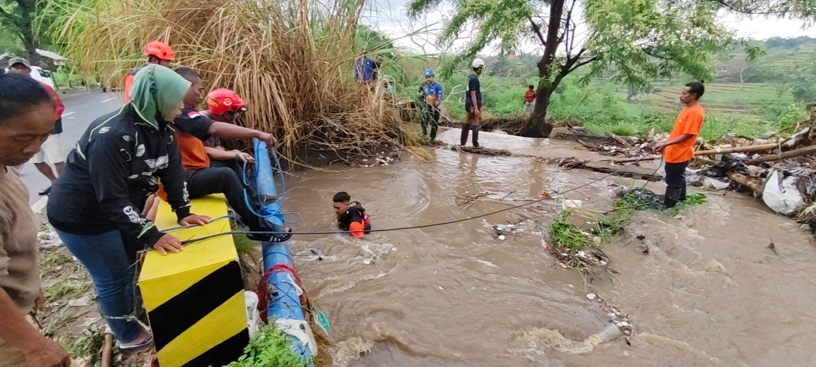 PENCARIAN: Petugas BPBD Kabupaten Mojokerto bersama relawan mencari motor yang terseret banjir di Jalan Raya Mojosari - Pacet, Desa Warugunung, Kecamatan Pacet, Rabu (22/10) sore.