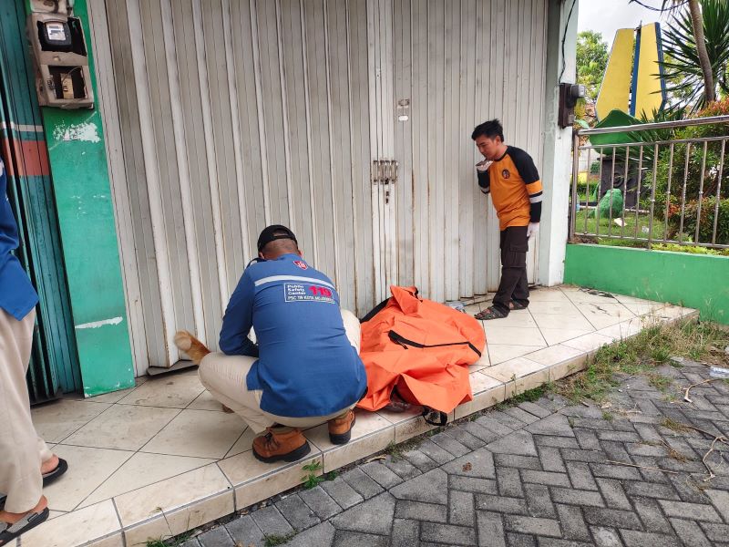 NAHAS: Petugas mengevakusi mayat lansia di teras ruko Jalan Gajah Mada, Kota Mojokerto, Minggu (26/10).