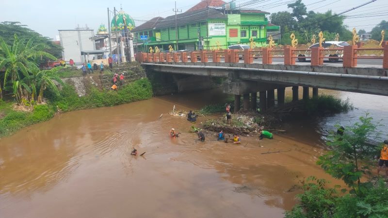 SUMBAT ARUS: Petugas gabungan melakukan pembersihan di aliran Sungai Brangkal untuk mengangkat sampah yang tersangkut di bawah jembatan Jalan KH Usman, Kelurahan Surodinawan, Kecamatan Prajurit Kulon,