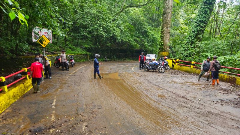 PEMBERSIHAN: Personel Polsek Pacet dan Tahura R. Soerjo membersihkan material longsor di jembatan Blok Lemah Bang, Desa/Kecamatan Pacet.
