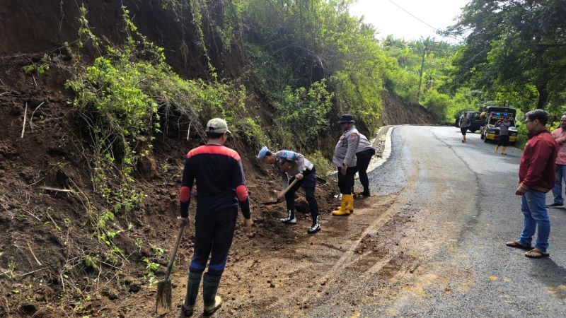 PENANGANAN: Petugas Polsek Pacet bersama warga mengevakuasi material longsor di Dusun/Desa Cembor, Kecamatan Pacet, Kamis (6/11).