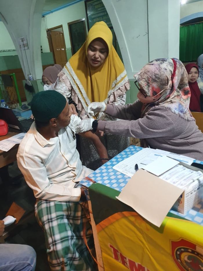 PEDULI WARGA: Kepala Desa Brangkal Nur Ely Suryani membantu tim medis memeriksa kesehatan warga.