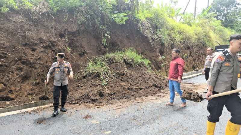 PEMBERSIHAN: Petugas gabungan membersihkan material longsor yang menutup akses Jalan Raya Dusun/Desa Cembor, Kecamatan Pacet, Kamis (6/11) lalu.