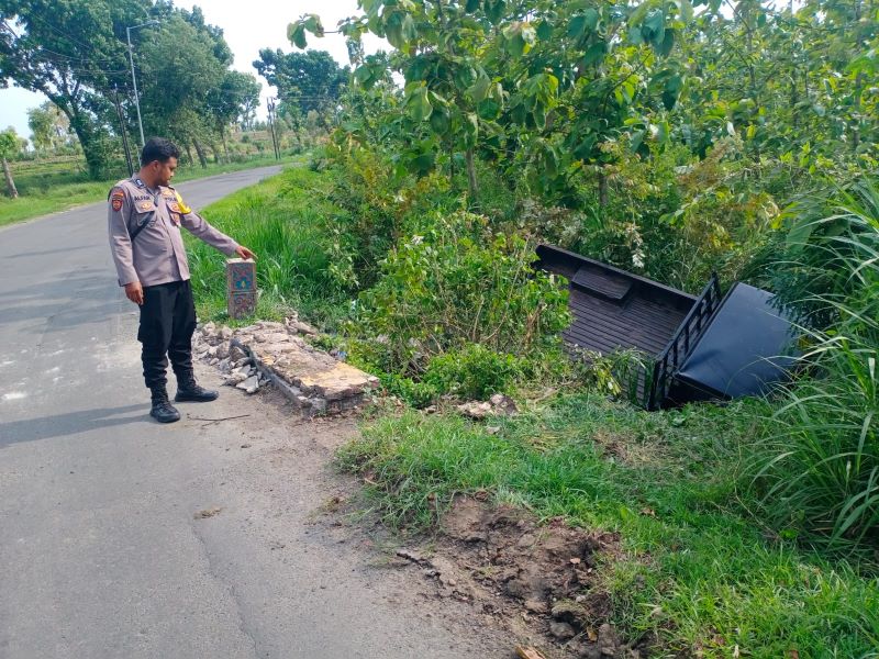TERPEROSOK: Petugas Polsek Dawarblandong menangani pikap yang masuk parit di Jalan Raya Desa Suru, kemarin (10/11).