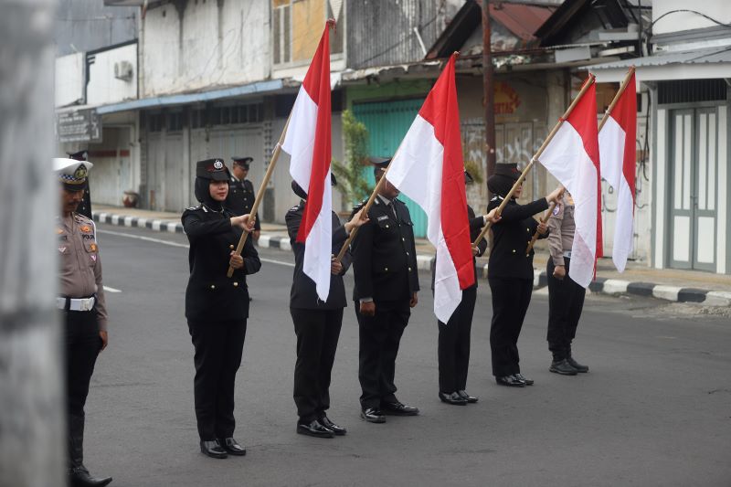 DUA MENIT: Anggota kepolisian dari Polres Mojokerto Kota bersama pengendara dan warga sejenak mengheningkan cipta dan mendoakan para pahlawan di simpang empat Jalan Mojopahit dan Jalan Bhayangkara.