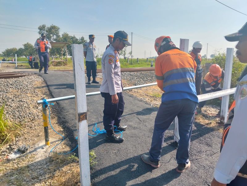 DIBUKA TERBATAS: Petugas DPRKP2 Kabupaten Mojokerto dan PT KAI memasang portal di perlintasan JPL 39, Dusun Wonoayu, Desa Kepuhanyar, Kecamatan Mojoanyar, Oktober lalu.