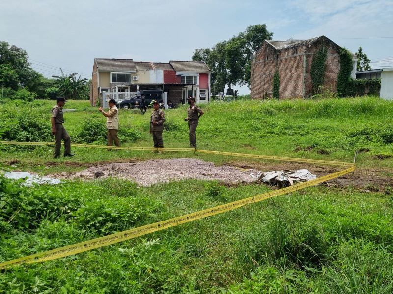 BERBAHAYA: DLH Kabupaten Mojokerto pasang garis pengawas PPLH pada dumping limbah B3 terjadi di lahan kosong dalam kawasan Perumahan Jambu Indah Residence, Desa Jambuwok, Kecamatan Trowulan, kemarin.
