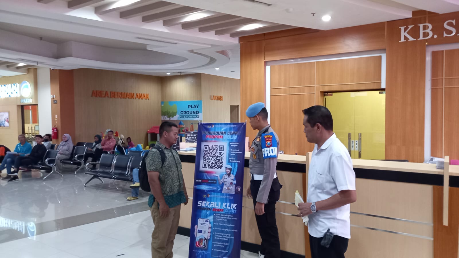 JEMPUT BOLA: Propam Polres Mojokerto Kota memasang banner sosialisasi pelaporan di MPP Gajah Mada Kota Mojokerto, Kamis (13/11).