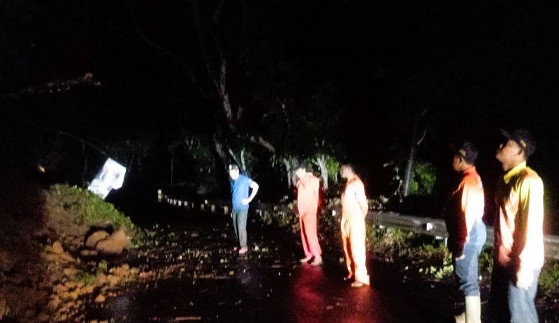 RAWAN LONGSOR: Petugas bersama relawan mengevakuasi material longsoran di Jalan Raya Desa Cembor, Kecamatan Pacet, Rabu (12/11) malam.