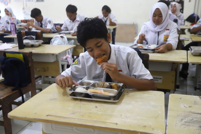 BERGULIR LAGI: Sejumlah pelajar menyantap menu Makan Bergizi Gratis di SMP 3 Kota Mojokerto, kemarin (17/11).