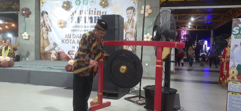 RESMI DIMULAI: Kepala MI Darul Huda Kota Mojokerto Riha Mustofa memukul gong sebagai simbolis diluncurkannya SPMB Misdha.