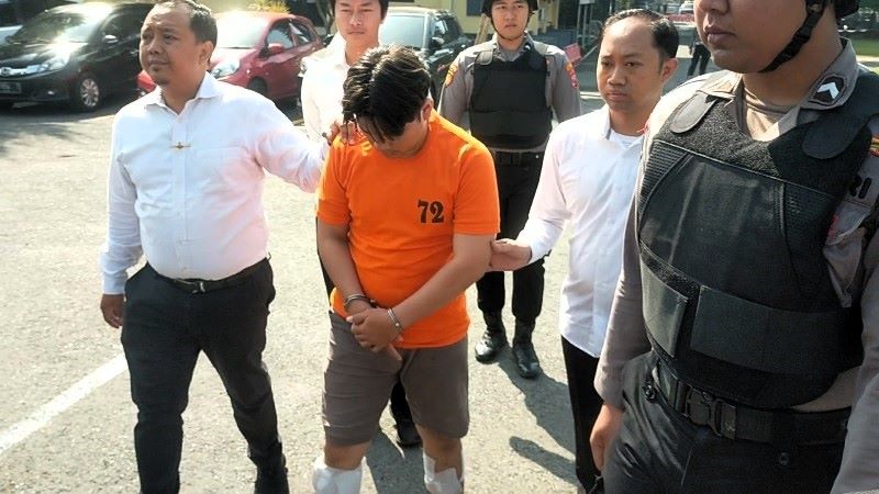 TAHANAN: Alvi Maulana (kaos oranye) hanya tertunduk saat digiring petugas ke sel tahanan usai koferensi pers di Polres Mojokerto, September lalu.