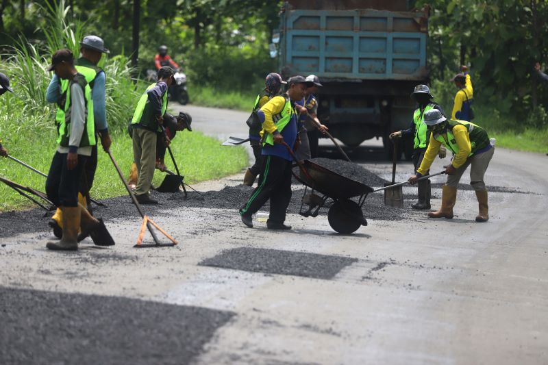 PERBAIKAN JALUR: Sejumlah pekerja melakukan tambal sulam jalan di area hutan jati Desa Suru, Kecamatan Dawarblandong. Memasuki musim hujan jalur Mojokerto-Gresik via Dawarblandong .