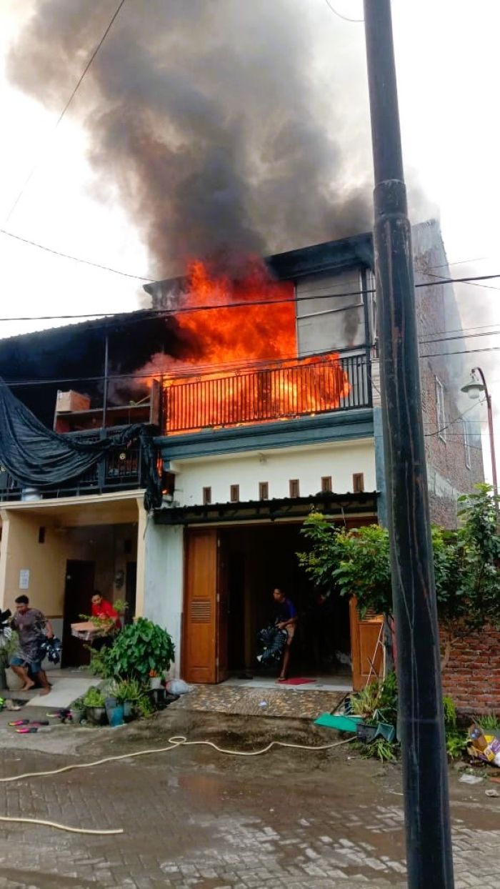 MEMBARA: Sejumlah karyawan menyelamatkan perabotan dan bahan-bahan sepatu saat api membakar home industry sepatu di Desa Blimbingsari, Kecamatan Sooko, kemarin (22/11).