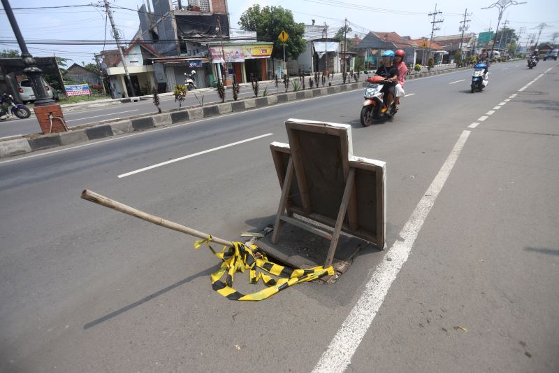BERBAHAYA: Titik penutup saluran air yang jebol di ruas Jalan Empunala, Kota Mojokerto yang dipasang penanda agar pengendara berhati-hati.