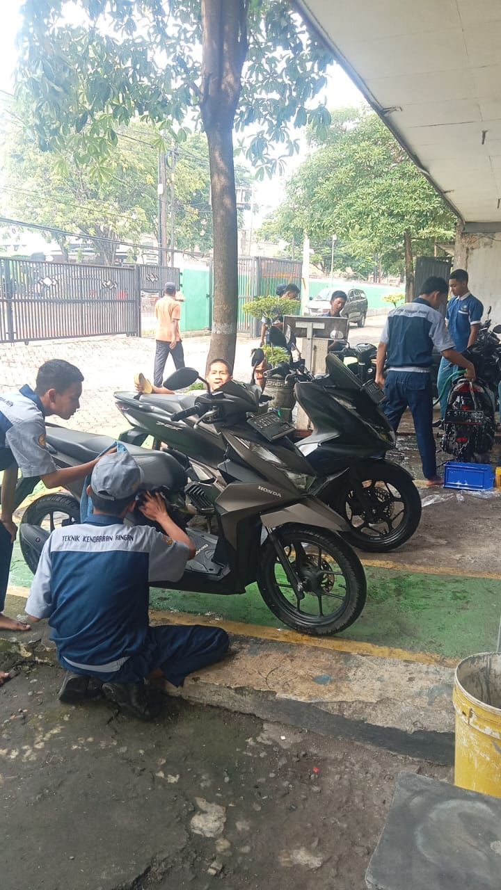APRESIASI: Siswa SMKN 1 Pungging mencuci dan memoles kendaraan motor para guru.