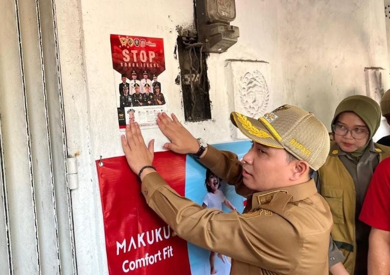 STOP ROKOK ILEGAL: Bupati Muhammad Albarraa memasang stiker gempur rokok ilegal saat sidak di Pasar Pandan, Desa Pandanarum, Kecamatan Pacet, Senin (11/8) lalu.