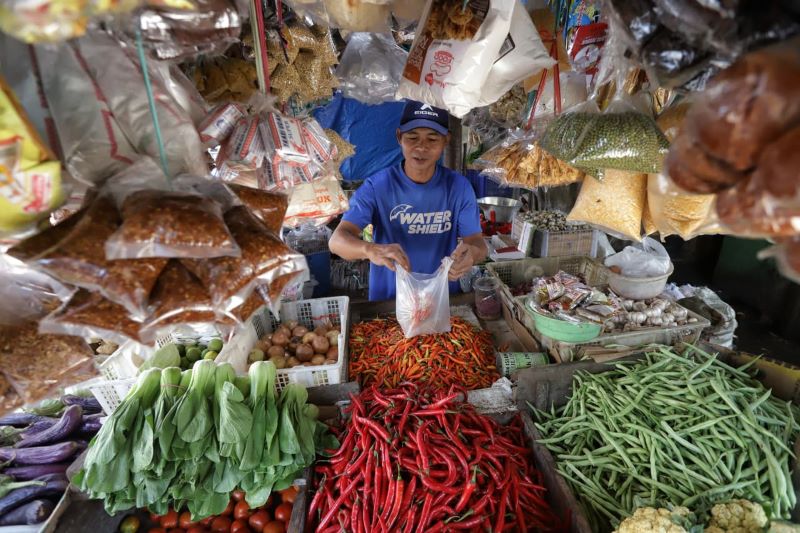 KOMODITAS PANGAN: Pedagang di Pasar Tanjung Anyar, Kota Mojokerto, sedang melayani pembeli, kemarin (27/11). Sejumlah harga bapok terpantau naik jelang akhir tahun.