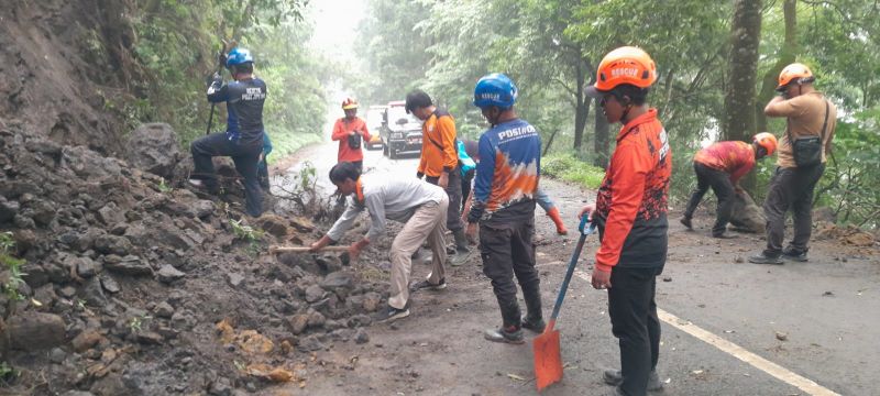 LONGSOR SUSULAN: Tim BPBD Kabupaten Mojokerto dan relawan membersihkan material longsor di Jalur Pacet-Cangar, kemarin (28/11).
