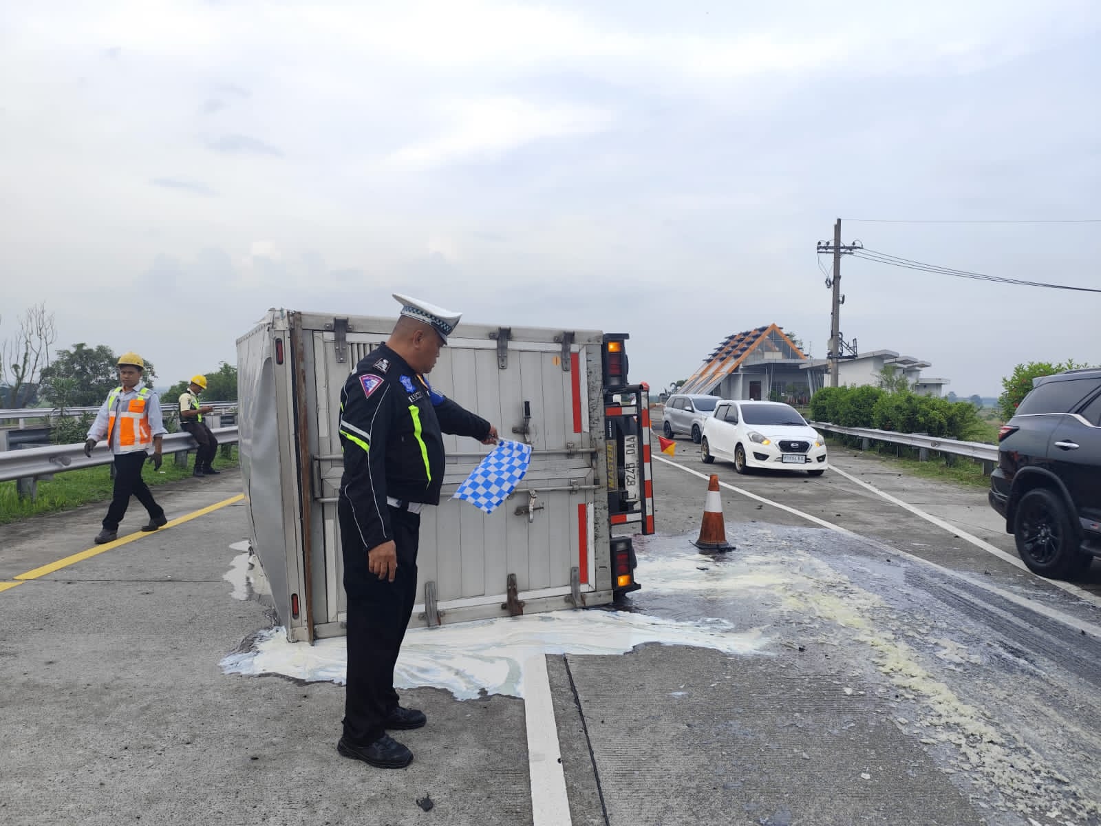 MELINTANG: Truk boks nopol L 8245 DAA terguling usai mengalami pecah ban di ruas tol Jomo KM 711/400 jalur B, Jumat (28/11) sore.