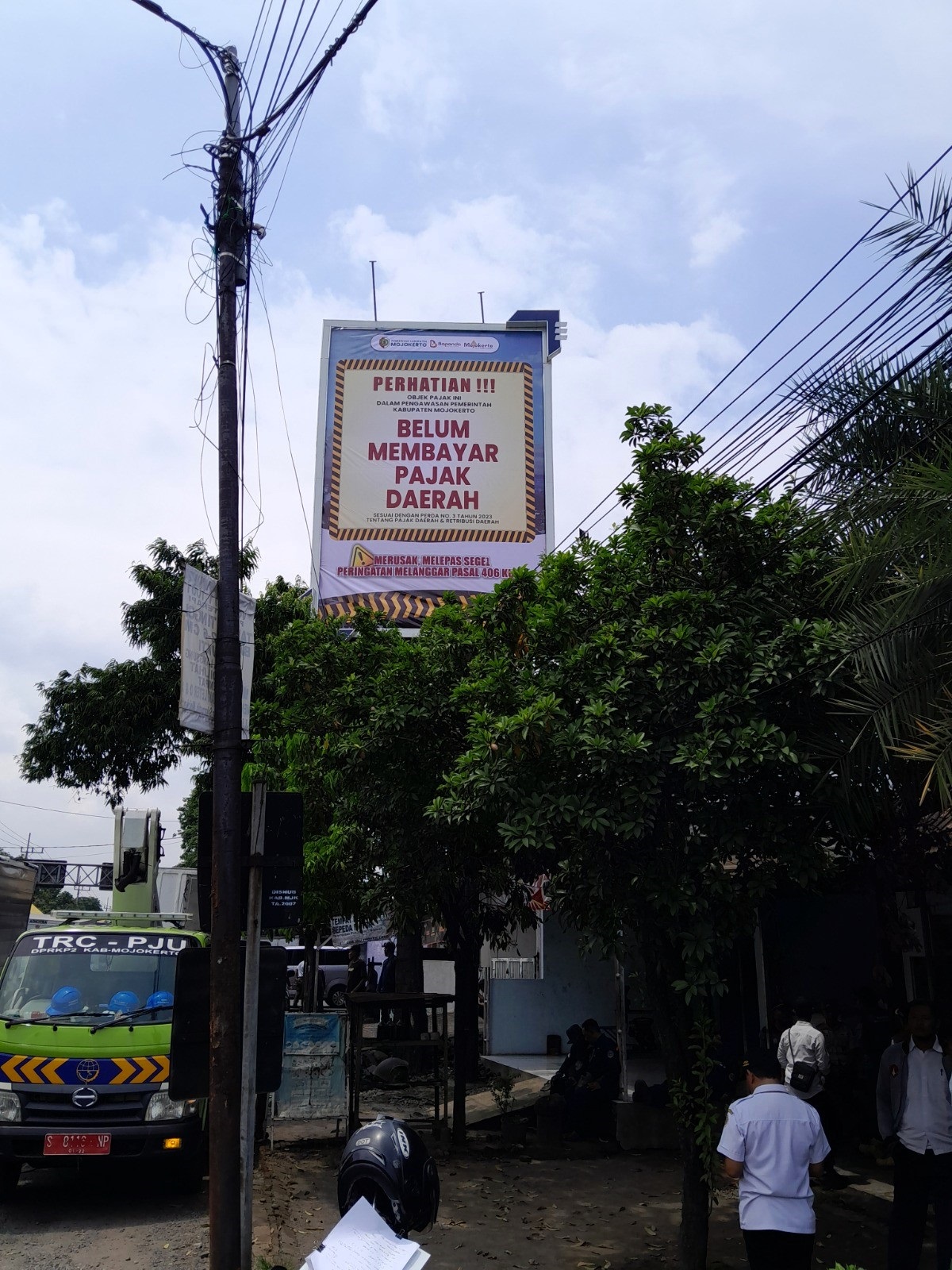 MELANGGAR REGULASI: Petugas gabungan menyegel reklame iklan rokok di Desa Pekukuhan, Kecamatan Mojosari.