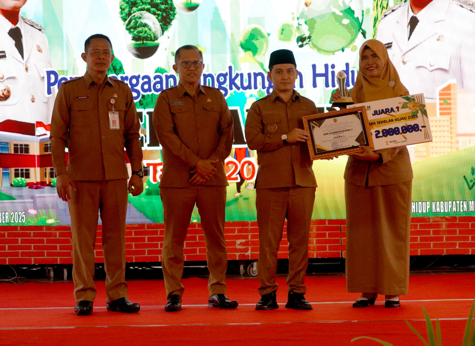 BERGENGSI: Kepala SDN Sumbergirang 1, Ririn Faridah menerima piala dan penghargaan juara 1 Sekolah Hijau tingkat Kabupaten Mojokerto dari Bupati Muhammad Albarraa, Senin (8/12).
