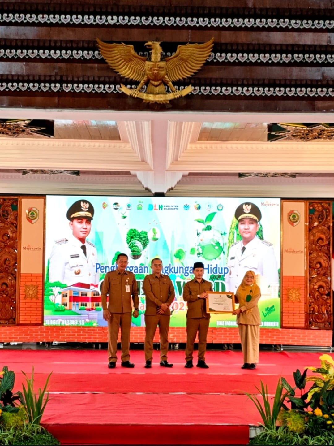 BERBASIS LINGKUNGAN: Kepala SMPN 1 Trowulan Ridha Dwi Wulansari diganjar penghargaan Sekolah Adiwiyata tingkat Provinsi Jatim oleh Bupati Mojokerto Muhammad Albarraa di Pendapa Pemkab Mojokerto, Senin