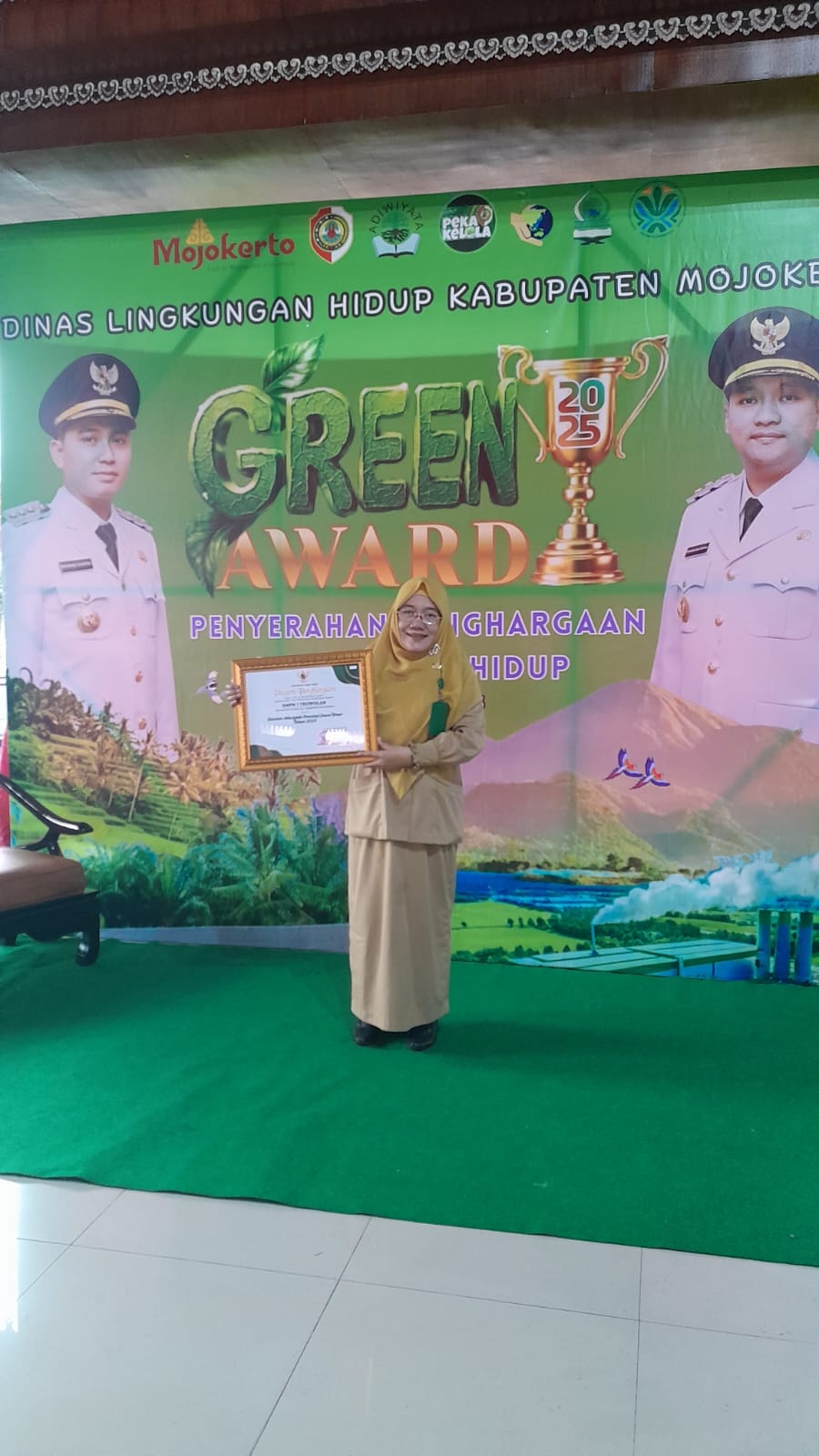 BERBASIS LINGKUNGAN: Kepala SMPN 1 Trowulan Ridha Dwi Wulansari diganjar penghargaan Sekolah Adiwiyata tingkat Provinsi Jatim oleh Bupati Mojokerto Muhammad Albarraa di Pendapa Pemkab Mojokerto, Senin
