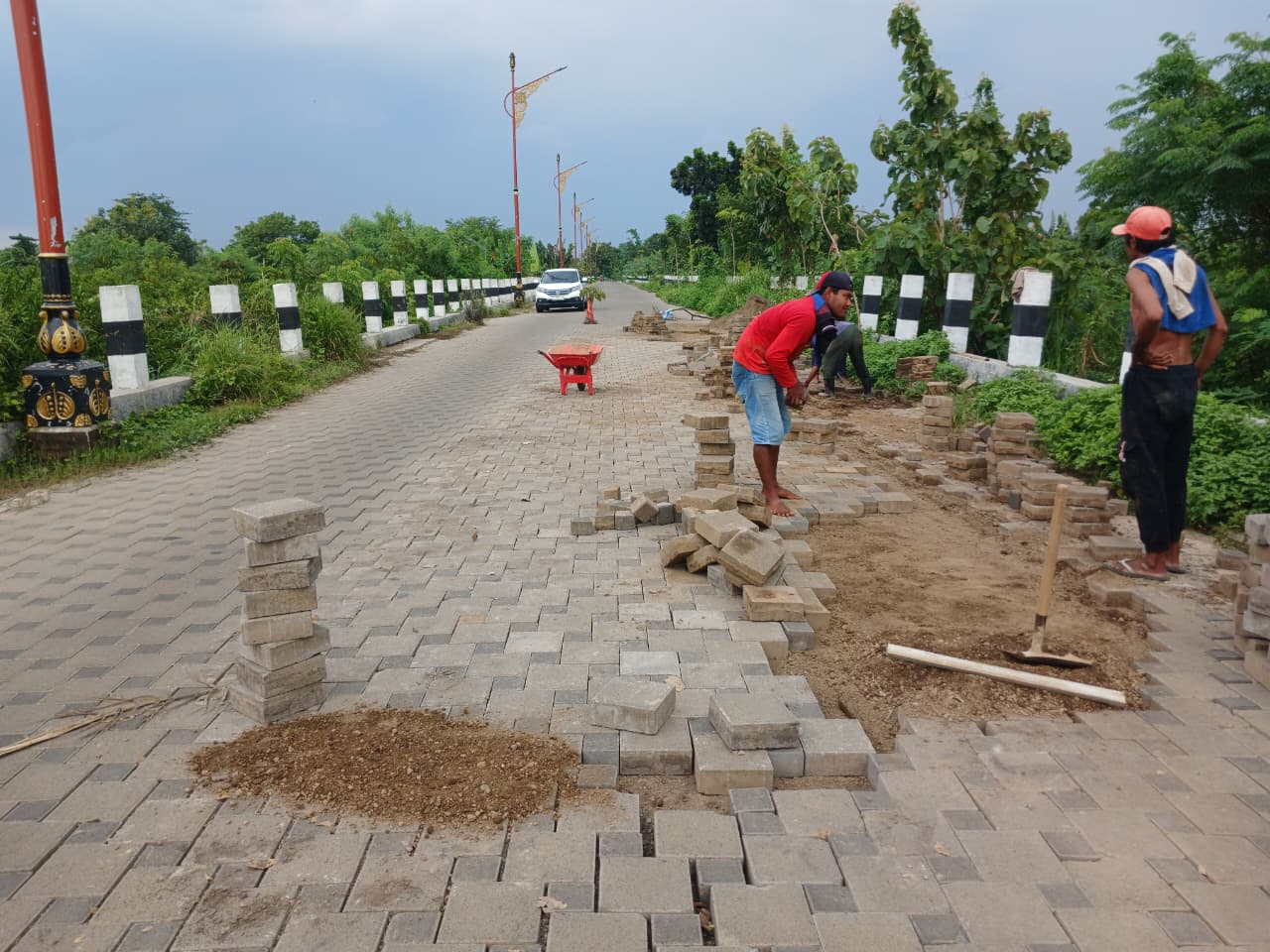 DIRAPATKAN: Pekerja memperbaiki paving yang renggang di Jalan Ir. Soekarno, kawasan TBM, Kecamatan Prajurit Kulon, Kota Mojokerto, kemarin (10/12).