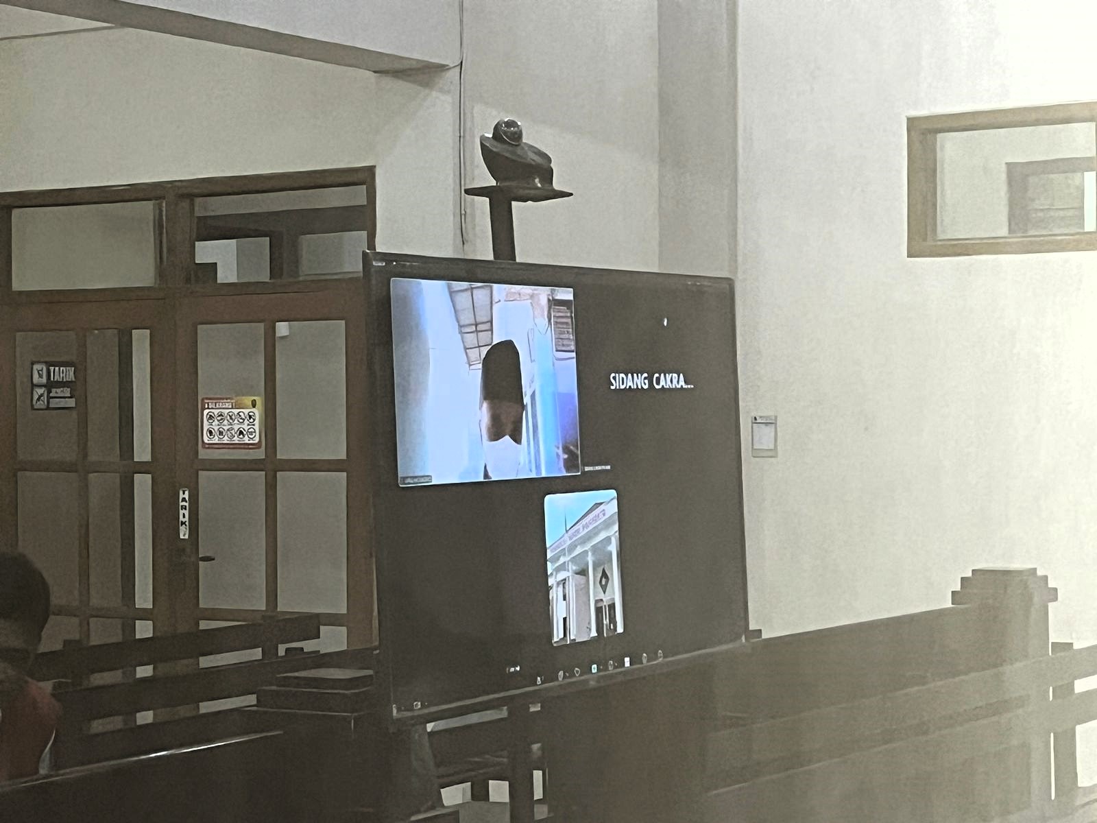 DARING: Prima Alif Eka Nur Adiat (dalam layar TV) menjalani sidang vonis secara daring karena sedang sakit, Rabu (10/12).