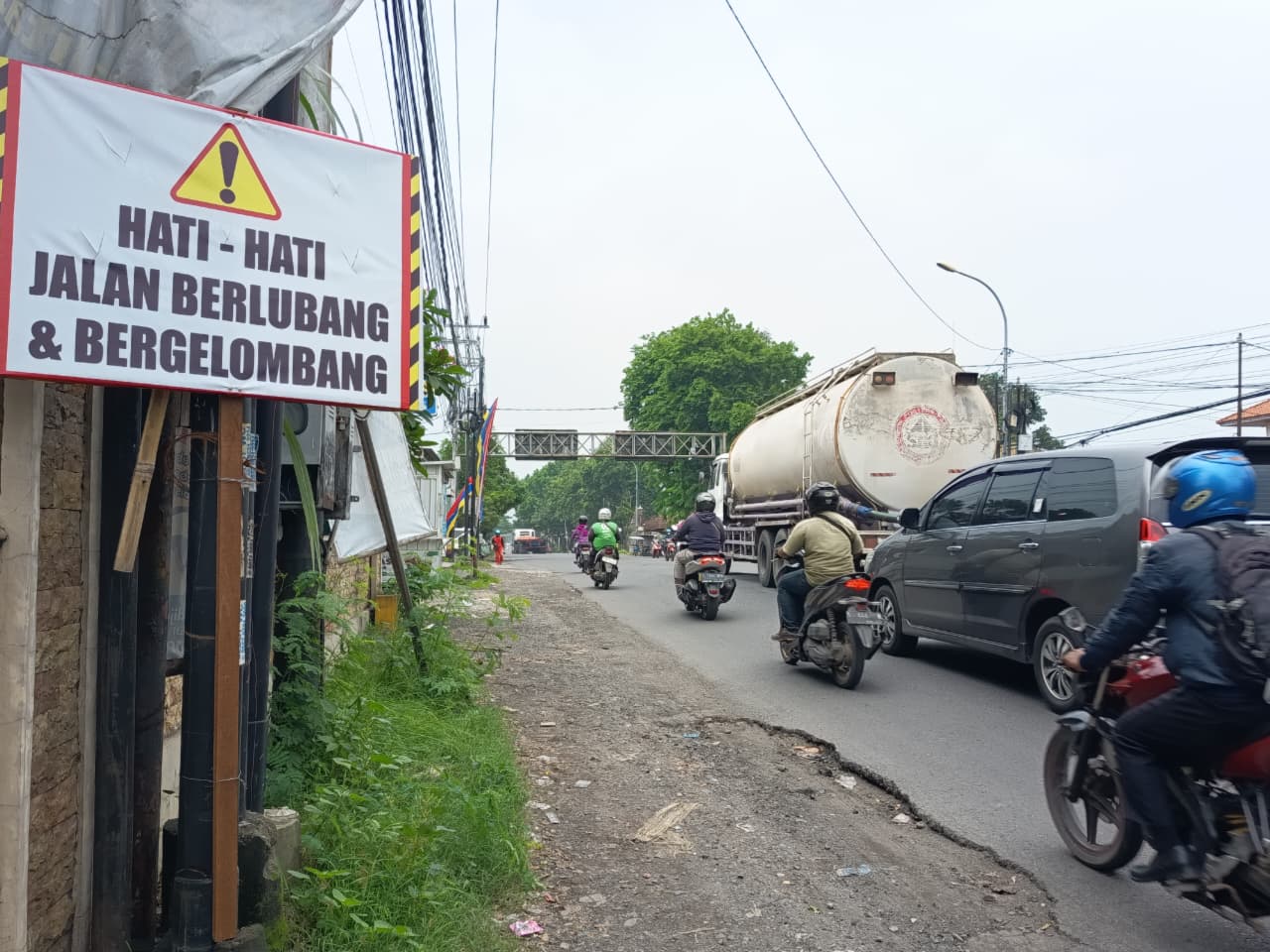 DIPERBAIKI: Pekerja dari BBJN melakukan penambalan dan penyulaman di Jalan Brawijaya, Kecamatan Pungging, Kabupaten Mojokerto, yang kondisinya berlubang dan bergelombang, kemarin (11/12).