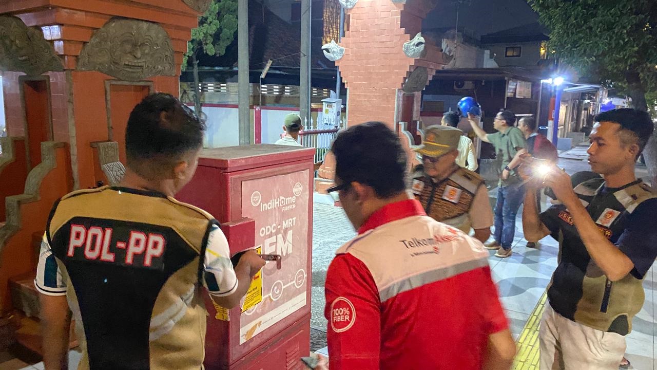 DIBUKA: Petugas Satpol PP Kota Mojokerto melepas segel pada perangkat ODC milik Telkom di Jalan Empunala, Sabtu (13/12) malam.