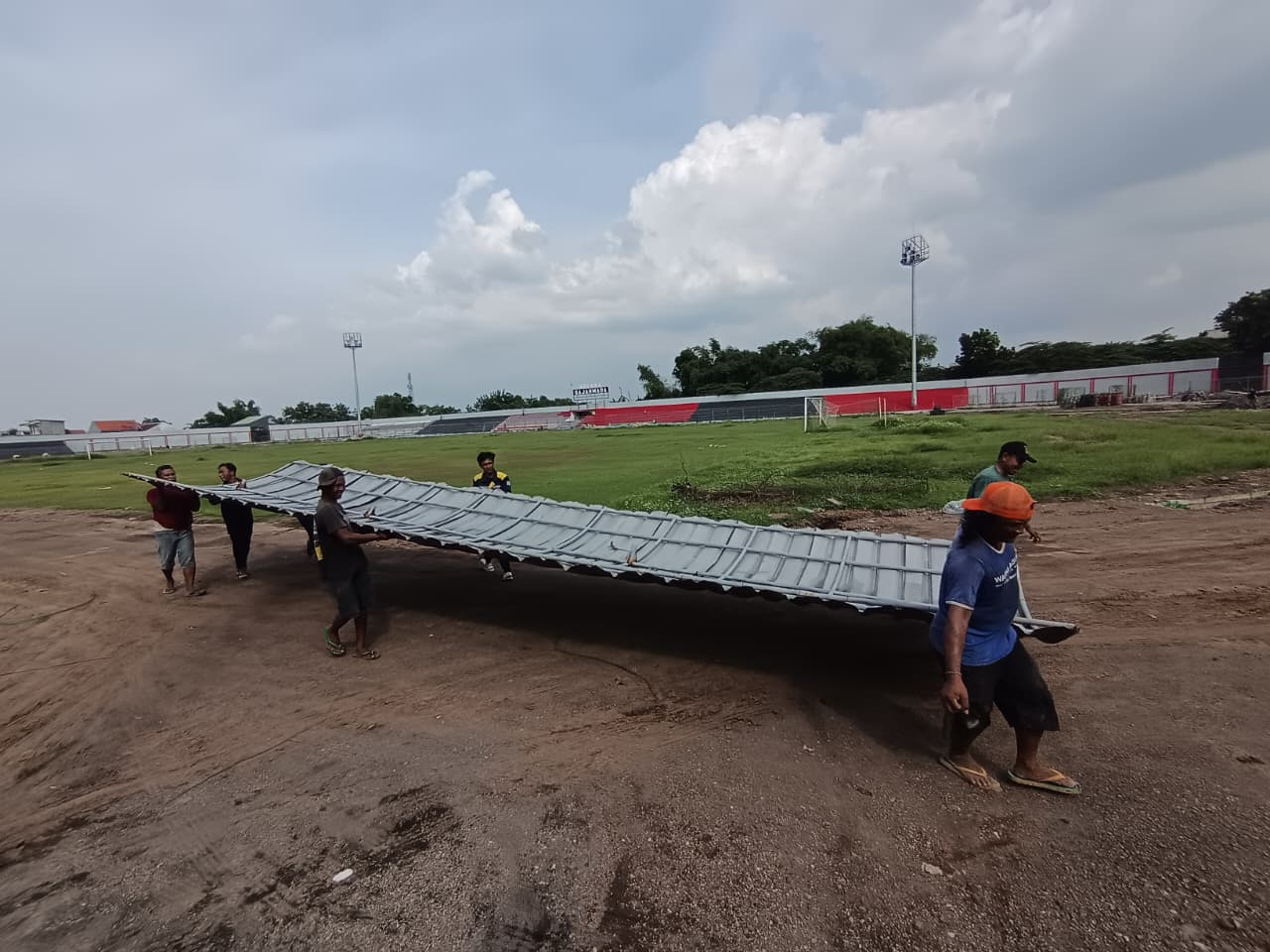 HARUS DIKEBUT: Pekerja proyek memindahkan bench pemain di Stadion Gajah Mada, Mojosari, Kabupaten Mojokerto untuk dilakukan renovasi, Senin (15/12).
