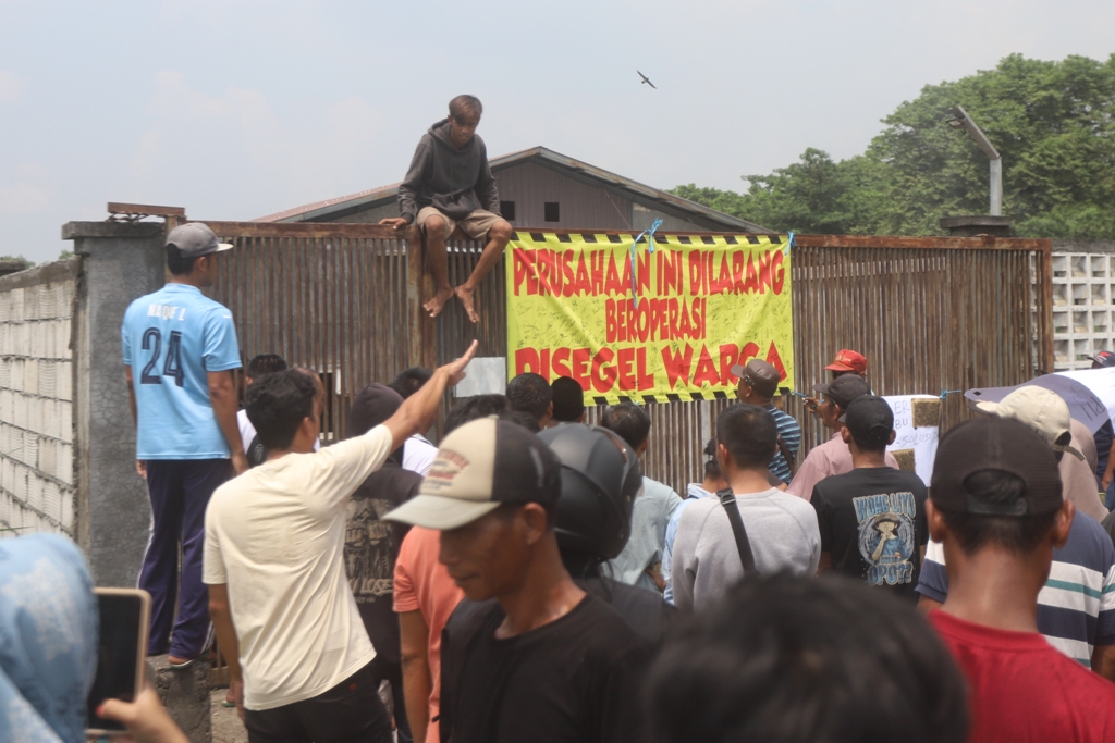 DIBLOKIR: Warga menyegel pintu gerbang kandang ayam di Desa Kumitir, Kecamatan Jatirejo, Kabupaten Mojokerto, kemarin (18/12).