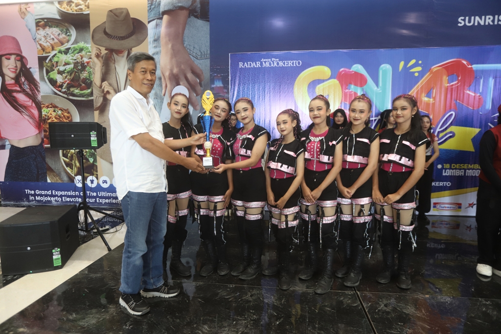 PENGHARAGAAN: Direktur Jawa Pos Radar Mojokerto M. Nur Kholis menyerahkan piala kepada para juara lomba modern dance.