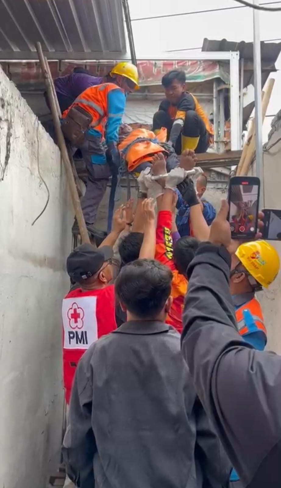 DRAMATIS: Tim gabungan melakukan proses evakuasi pekerja bangunan yang jadi korban tersengat arus listrik dari atap bangunan untuk dilarikan ke rumah sakit, Kamis (18/12).