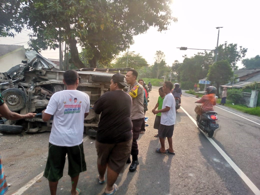 TERGULING: Pikap muatan bahan pakan ternak terguling usai mengalami kecelakaan tunggal di Jalan Raya Desa Betro, Kecamatan Kemlagi, Kamis (18/12) pagi.