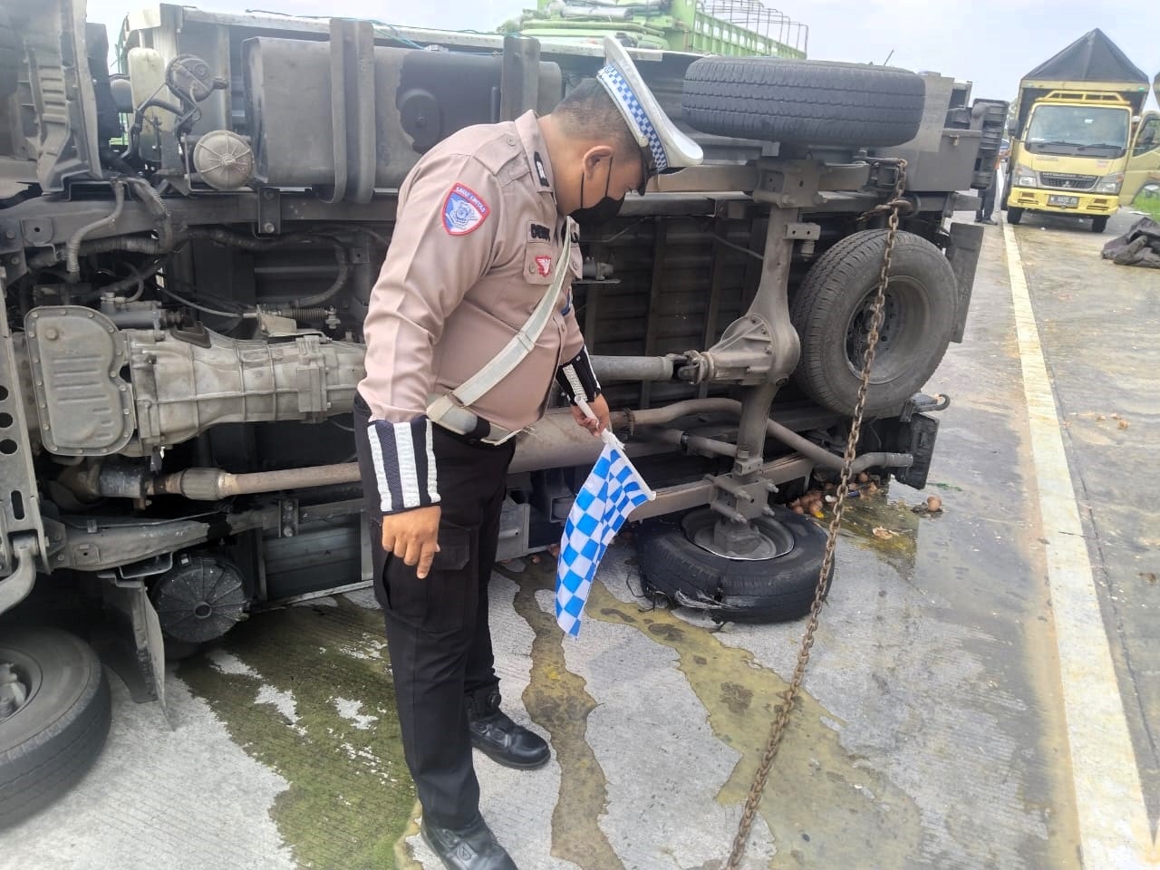 PEMICU LAKA: Petugas menunjukkan kondisi ban belakang pikap yang pecah usai mengalami kecelakaan tunggal di Tol Jomo KM 709, Sabtu (20/12).