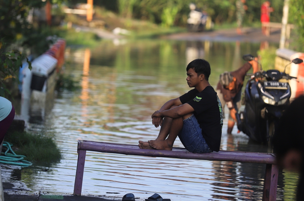 AKSES TERPUTUS: Aktivitas warga Desa Pulorejo, Kecamatan Dawarblandong, terhambat akibat banjir luapan Anak Kali Lamong, Minggu (21/12).