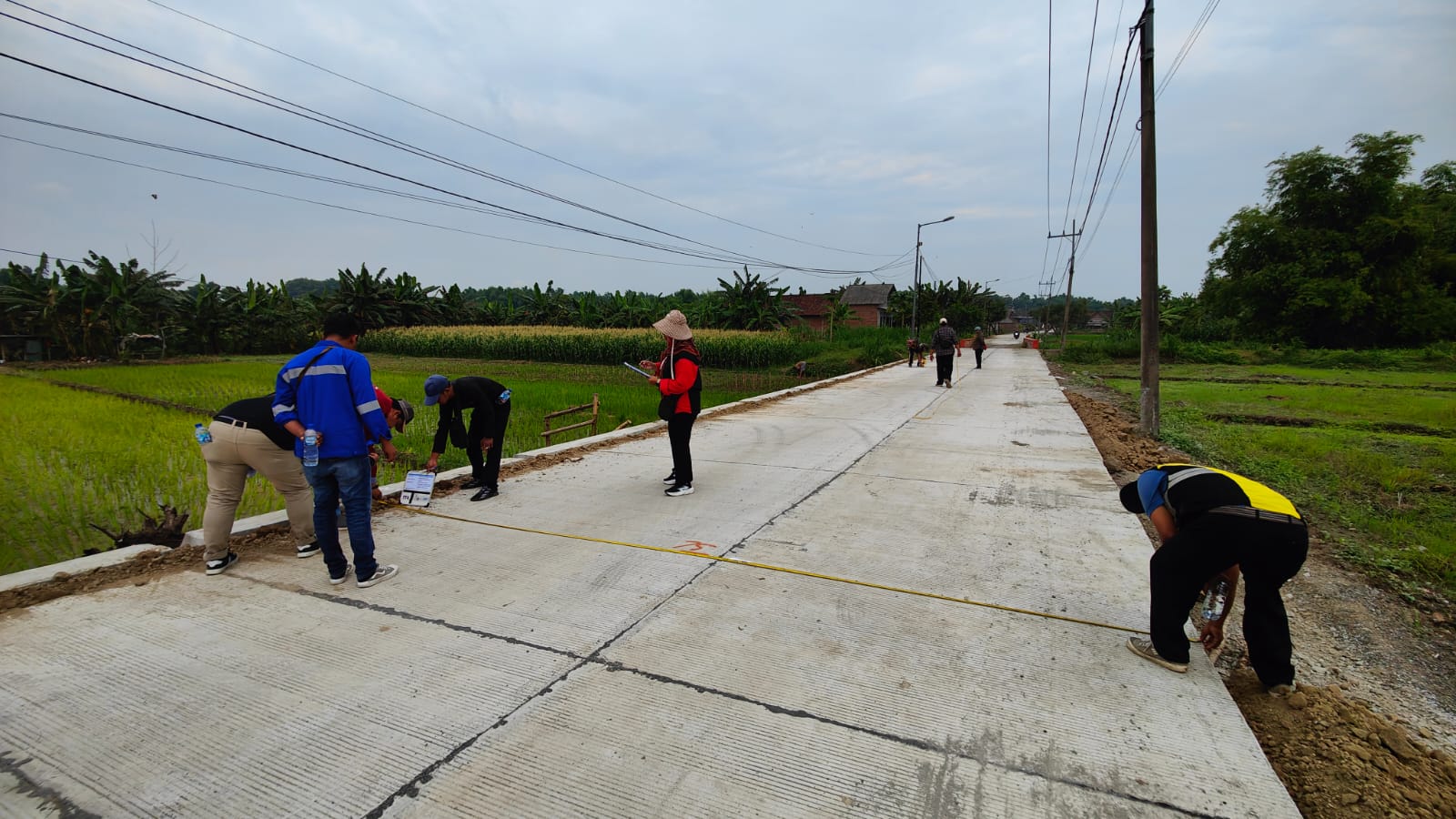 MULUS: Petugas Dinas PUPR Kabupaten Mojokerto bersama tim melakukan pengecekan hasil proyek betonisasi jalan poros Desa Parengan, Kecamatan Jetis.
