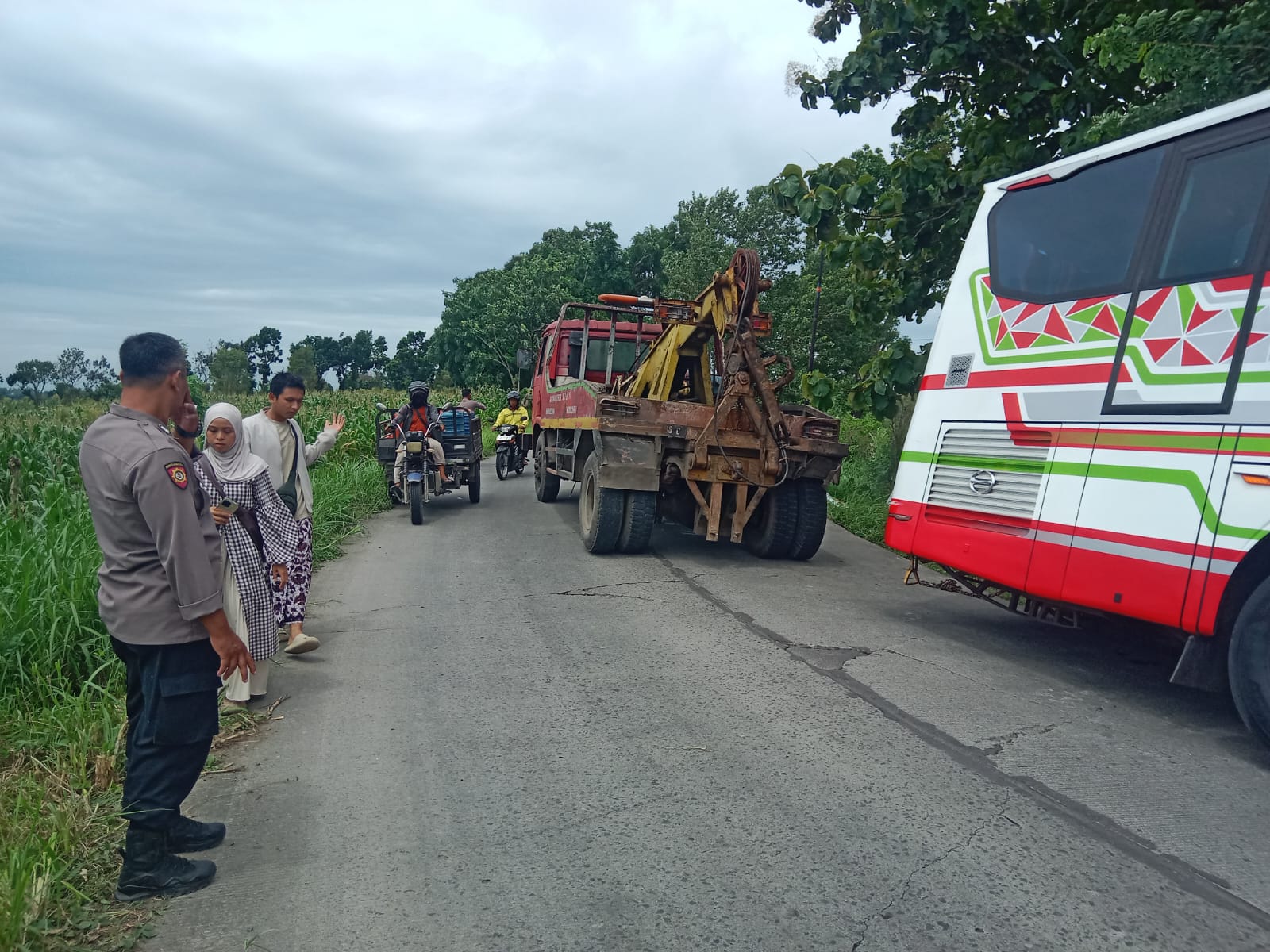 DIDEREK: Armada bus parwisata milik PO Titipan Illahi diderek usai terperosok Jalan Raya Desa Suru, Kecamatan Dawarblandong, Sabtu (27/12) pagi.