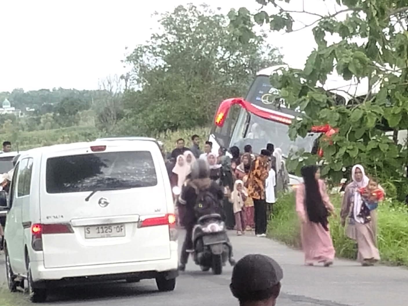 CELAKA: Armada bus parwisata milik PO Titipan Illahi terperosok saat melintasi Jalan Raya Desa Suru, Kecamatan Dawarblandong, Sabtu (27/12) pagi.
