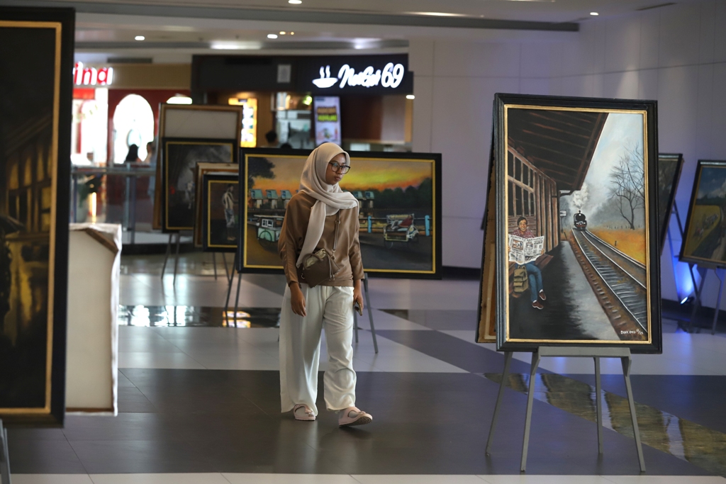 SURVEI TERBUKA: Jurnalis sekaligus pelukis Diak Eko menjelaskan karya buatannya kepada pengunjung Sunrise Mall 2 Mojokerto dalam event Gen Art, Sabtu (27/12).